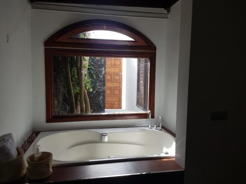 een badkuip in een badkamer met een raam bij VILLA FENIX in Puerto del Carmen