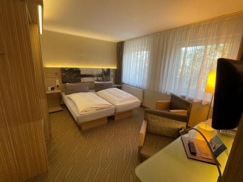 a hotel room with a bed and a couch at Hotel am Untersee in Bantikow