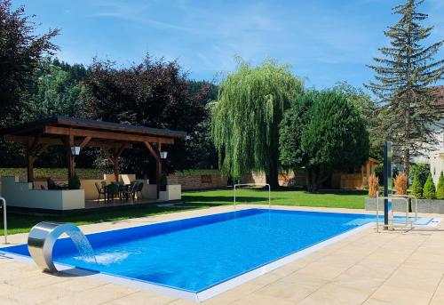 a swimming pool in a yard with a gazebo at Hotel Charlotte in Innsbruck