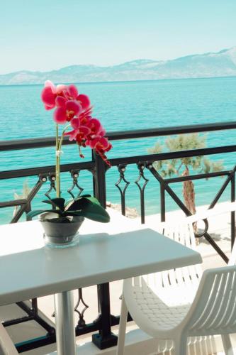 a vase with a flower on a table on a balcony at Hotel Kyani Akti in Xylokastron