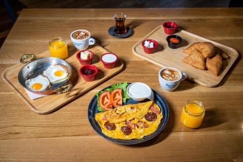 a table with two trays of food and eggs and bread at Hotel 4 Llulla in Pristina