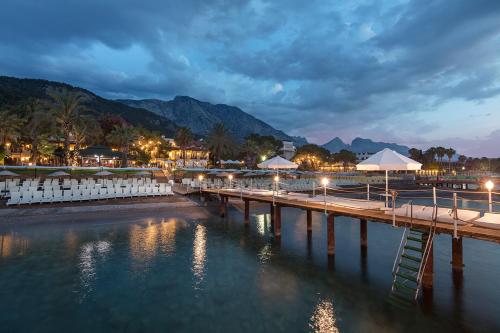 a dock with lights on the water at night at Grand Ring Hotel in Beldibi