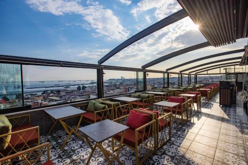restauracja ze stołami i krzesłami oraz widokiem na miasto w obiekcie Grand Balyan Hotel & Restaurant w Stambule