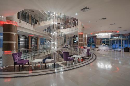 a lobby with purple chairs and tables in a building at Grand Ring Hotel in Beldibi