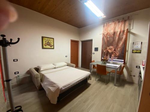 Schlafzimmer mit einem Bett, einem Tisch und einem Fenster in der Unterkunft La casa di nonna rosetta in Cirò Marina