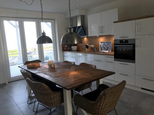 a kitchen with a wooden table and chairs at OceanView in Wittdün