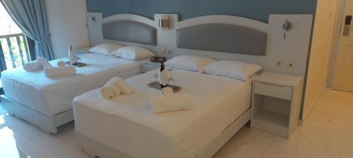 two beds in a hotel room with towels on them at Augusta Methoni Hotel in Methoni