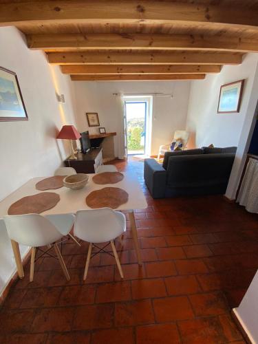 a living room with a table and chairs and a couch at CASA DA LAGINHA in Zambujeira do Mar