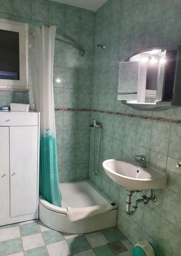 a bathroom with a sink and a shower and a toilet at Apartmani Huljić in Stari Grad