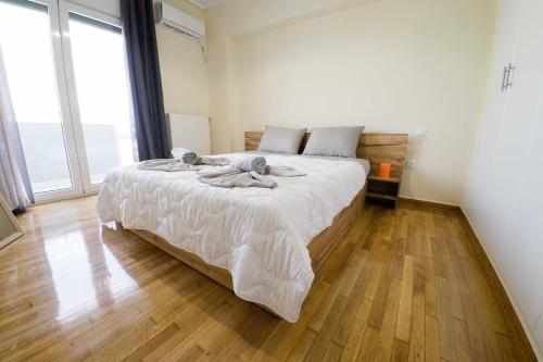um quarto com uma cama grande e piso em madeira em Argo Suite em Piraeus