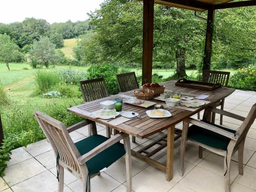 een houten tafel en stoelen op een terras bij MaBelle rêve B&B in Saint-Pierre-de-Côle