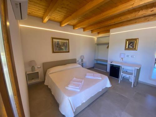 a bedroom with a large bed and a desk at B&B Pettirosso in San Teodoro