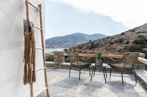 a patio with chairs and a table with a view at Nesea Sifnos - Luxury Residences in Platis Yialos Sifnos