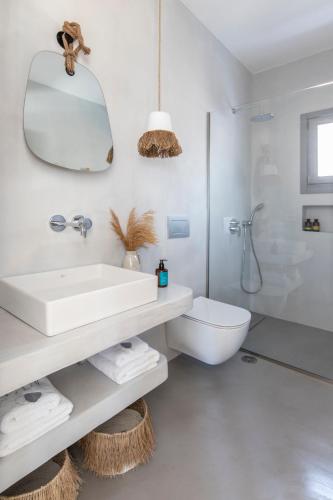 a white bathroom with a sink and a toilet at Nesea Sifnos - Luxury Residences in Platis Yialos Sifnos