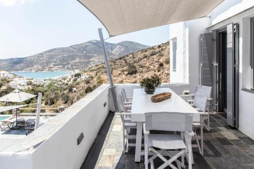 a balcony with a table and chairs and a view at Nesea Sifnos - Luxury Residences in Platis Yialos Sifnos