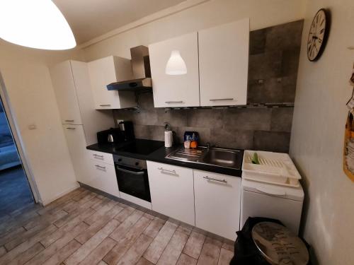 eine kleine Küche mit weißen Schränken und einem Waschbecken in der Unterkunft Apartments Center Colmar 5 in Colmar