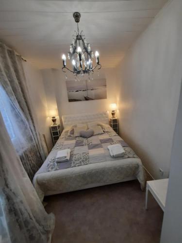 sypialnia z dużym łóżkiem i żyrandolem w obiekcie Apartments Center Colmar 5 w mieście Colmar