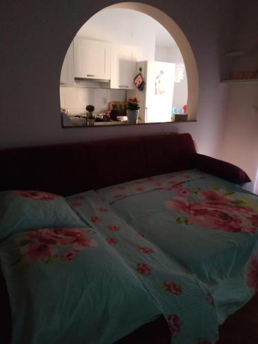 ein Bett mit einer blauen Decke mit Blumen drauf in der Unterkunft Melita studio apartment in Split