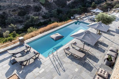 an overhead view of a swimming pool with chairs and umbrellas at Nesea Sifnos - Luxury Residences in Platis Yialos Sifnos