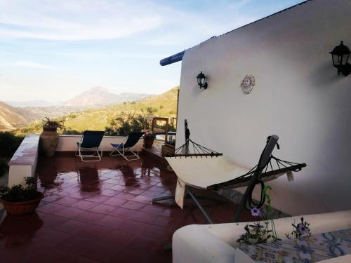 a house with a porch with a view of mountains at L'Opuntia sul lago in Caccamo
