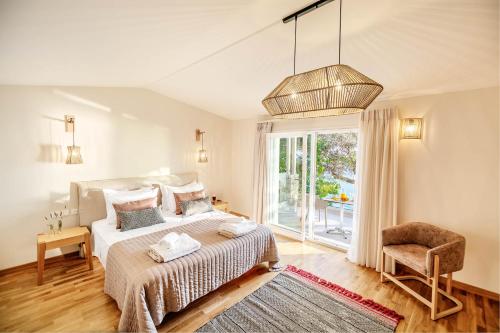 a bedroom with a bed and a chair and a window at Ocean View Luxury Villa Ethra in Corfu Town