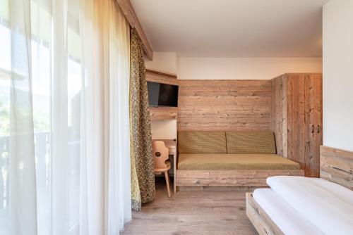 a bedroom with a bed and a window at Hotel Christine in Gargazzone