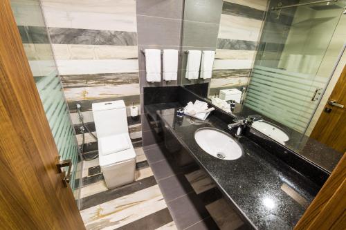 فندق وايت ديموند - النزهة في جدة: حمام مع حوض ومرآة