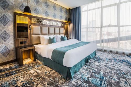 a bedroom with a large bed and a large window at Wow Diamond Hotel in Jeddah