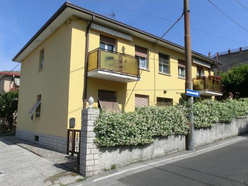 un edificio giallo con balcone su una strada di Le Rose a Trieste