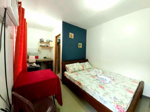 a small bedroom with a bed and a chair at Gaea's Apartments in Panglao Island