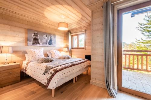 a bedroom with a bed and a large window at AUx SPORTS D HIVER in Courchevel