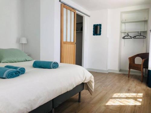 ein Schlafzimmer mit einem Bett mit blauen Kissen darauf in der Unterkunft Maison de ville, 2ch, La Petite Aure in Bayeux