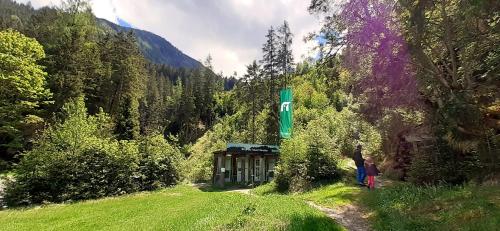 a small building in the middle of a grass field at Haus Weyerbach Apartments in Bramberg am Wildkogel