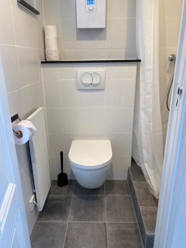 a small bathroom with a toilet and a shower at Cozy Tiny House Egmond aan Zee- 500m from Beach-North Sea in Egmond aan Zee