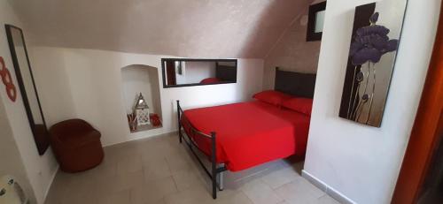 Un pequeño dormitorio con una cama roja en una habitación en La casetta nel claustro 2, en Altamura