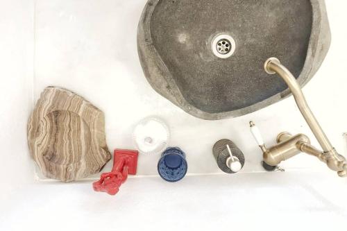 a bathroom sink with a faucet and other bathroom items at little cactus in Serifos Chora