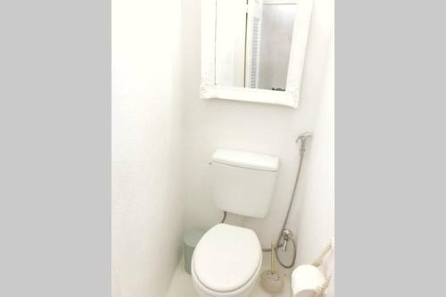 a white bathroom with a toilet and a mirror at little cactus in Serifos Chora