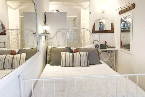 a room with a bed with pillows and a mirror at little cactus in Serifos Chora