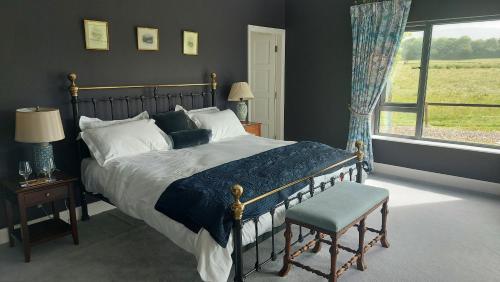 um quarto com uma cama, uma cadeira e uma janela em Coolcormack Stud B&B em Waterford