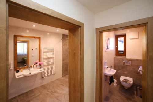 a bathroom with two sinks and a large mirror at Haus Alpenliebe in Piesendorf