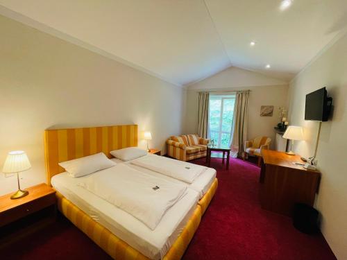 a bedroom with a large bed and a living room at Landhaus Hirschsprung in Detmold