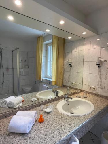 uma casa de banho com 2 lavatórios e um espelho grande em Landhaus Hirschsprung em Detmold
