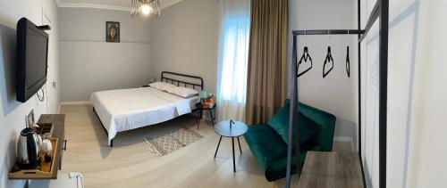 ein kleines Schlafzimmer mit einem Bett und einem Stuhl in der Unterkunft Homey in Tbilisi City