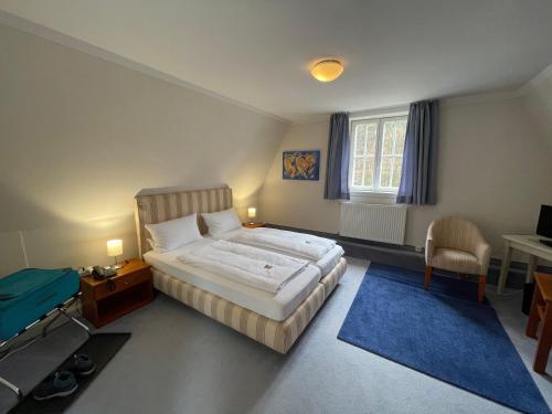 a bedroom with a bed and a desk and a chair at Landhaus Hirschsprung in Detmold