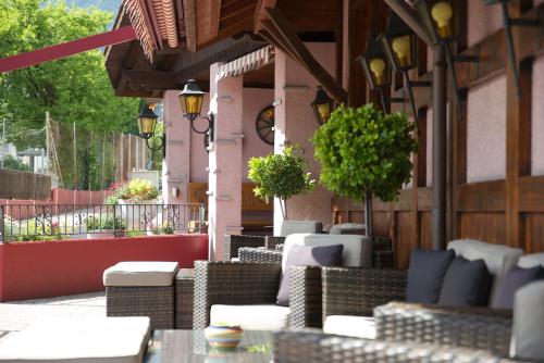 a patio with wicker chairs and tables on a building at Hotel Rössli in Interlaken