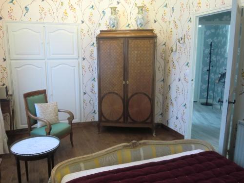 Cette chambre comprend une armoire, une table et des chaises. dans l'établissement Chambre d'hôtes LA BELLE SAISON, à Villedômer