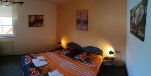 a bedroom with a bed and some pictures on the wall at Penzión Baltazár in Liptovská Lúžna