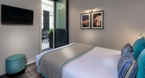 a bedroom with a bed and a tv and a chair at Montfleuri in Paris