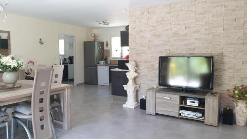 un salon avec une télévision à écran plat sur une table dans l'établissement Villa Entrechaux, à Entrechaux