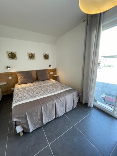- une chambre avec un lit et une grande fenêtre dans l'établissement Domaine Ravy-Azalée, à Saint-Symphorien-sur-Saône